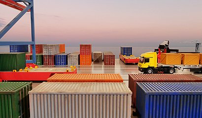 Containerhafen bei Sonnenuntergang mit beladenem Lkw