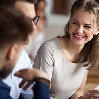 Drei Personen sitzen vor einem Computer und lernen gemeinsam