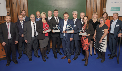 Gruppenbild der Gewinner des Healthcare Awards 2018, stehend auf blauem Boden