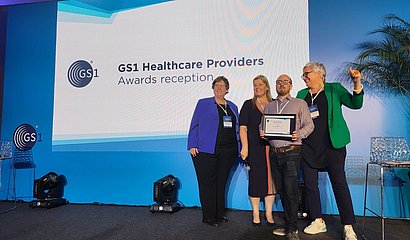 Siegerfoto beim GS1 Healthcare Provider Case Study Award 2023 auf der Bühne mit vier Personen