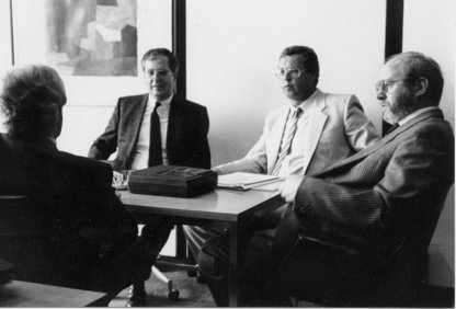 Original schwarz-weiß Foto aus den 70er-Jahren mit einem Round Table von vier männlichen Barcode-Pionieren in Anzug und Krawatte mit einem Aufnahmegerät aus dieser Zeit