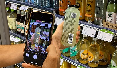 Scan eines 2D-Codes auf einer Jake's Lemonade Flasche am Kühlregal mit einem Smartphone