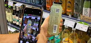 Scan eines 2D-Codes auf einer Jake's Lemonade Flasche am Kühlregal mit einem Smartphone