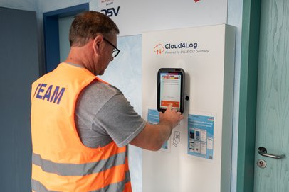 LKW-Fahrer checkt an Bildschirm der Self-Service-Lösung von Cloud4Log ein