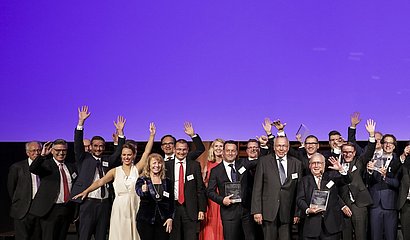 Foto der jubelnden Preisträger des ECR Award 2019 vor lila Hintergrund 