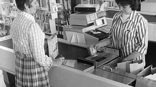 Frau beim Einkauf an einer Kasse mit UPC Scanner