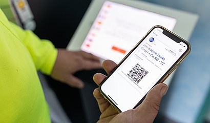 Digitaler Lieferschein wird als QR-Code auf Smartphone des LKW-Fahrers angezeigt