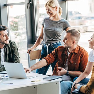 Eine Gruppe von jungen Leuten unterhalten sich im Büro