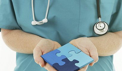 Foto: Healthcare Mitarbeiter hält Puzzleteile in der Hand