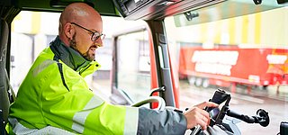 LKW-Fahrer bedient Handy in Fahrerkabine