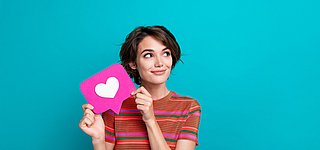 Efficient Consumer Response (ECR) Eine junge Frau hält eine Sprechblase mit einem Herz hoch